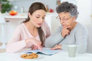 Young women helping Grandma with a crossword puzzle