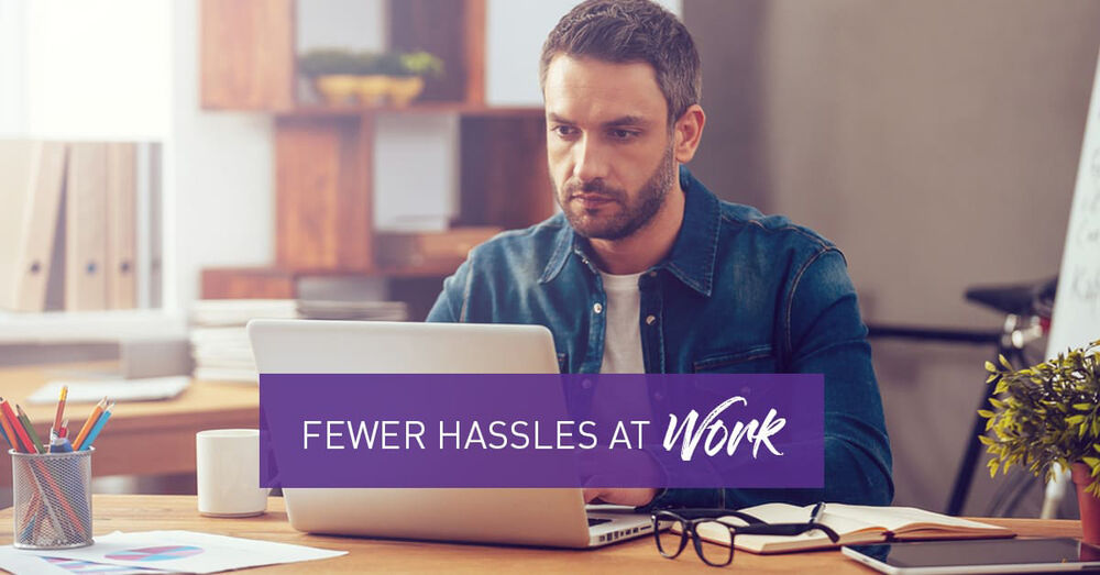 Man working on a laptop computer - Fewer Hassles At Work Graphic