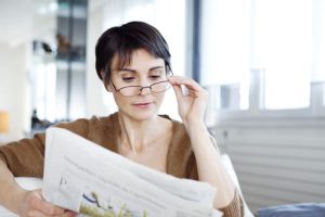 Women with glasses reading Newspaper