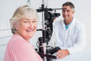 woman smiling getting eye exam from doctor