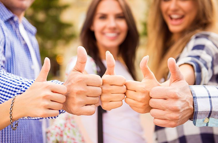 Group of young people giving thumbs up