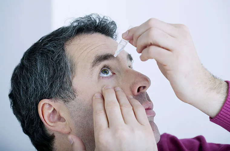Man using eye drops