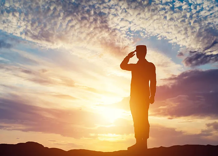 Soldier saluting at sunset