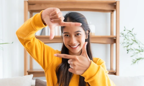 woman gesturing picture frame towards the camera framing her face with her hands