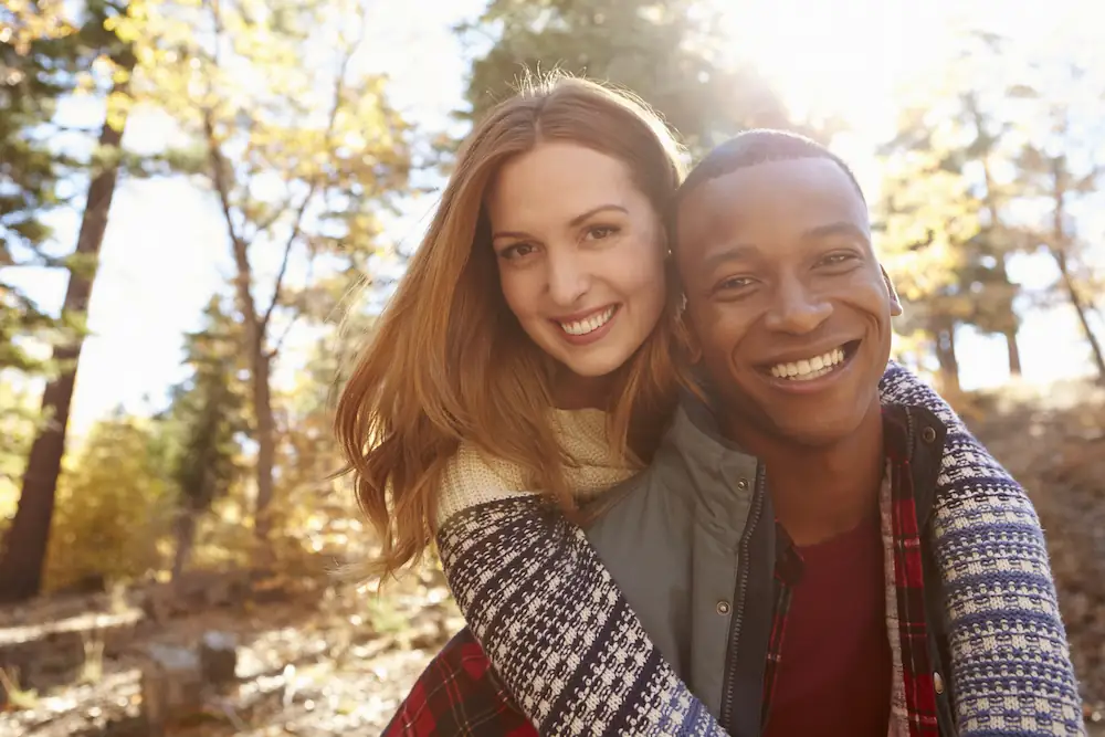Millennial couple smiling on a hike after lasik