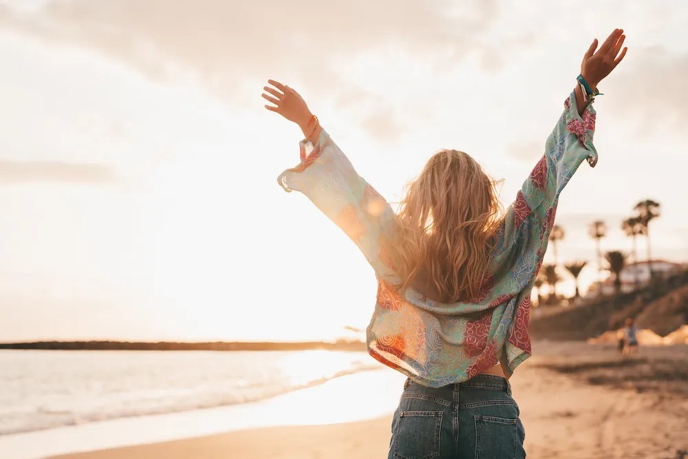 One happy beautiful woman walking on the sand of the beach enjoying and having fun at the sunset of the day